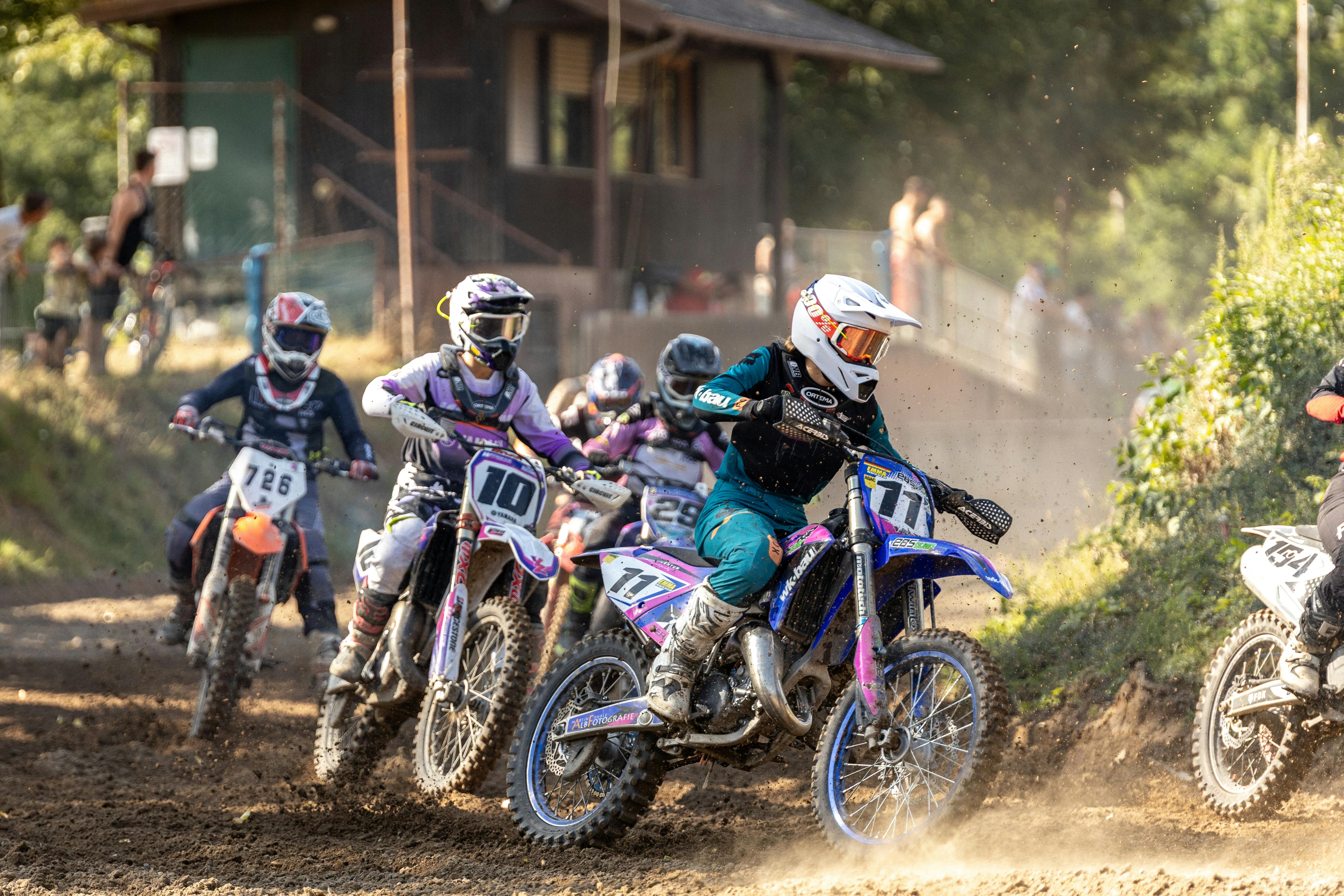 Dynamic motocross race with riders competing intensely on a dirt track outdoors.