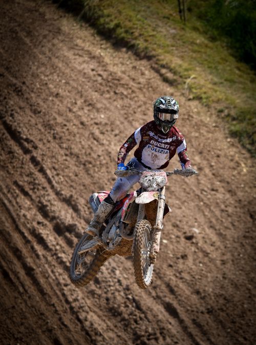 Free Exciting motocross rider jumping high on a dirt track, showcasing freestyle skill. Stock Photo
