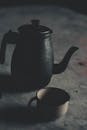 复古茶壶和杯子的艺术静物展现了戏剧性的阴影效果