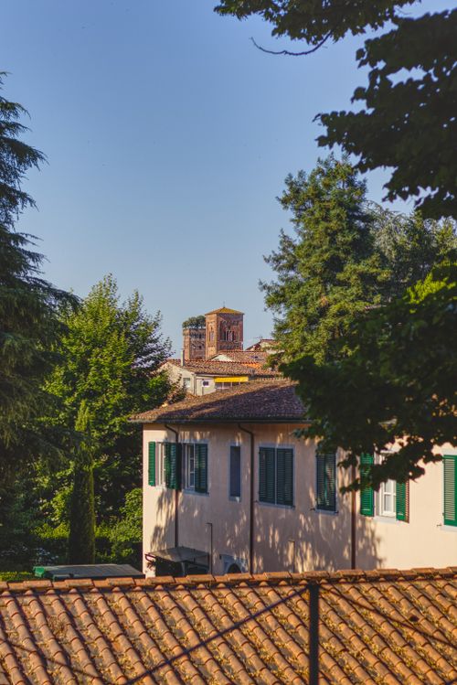 Free Charming Lucca scene featuring historic architecture and lush greenery under a clear sky. Stock Photo