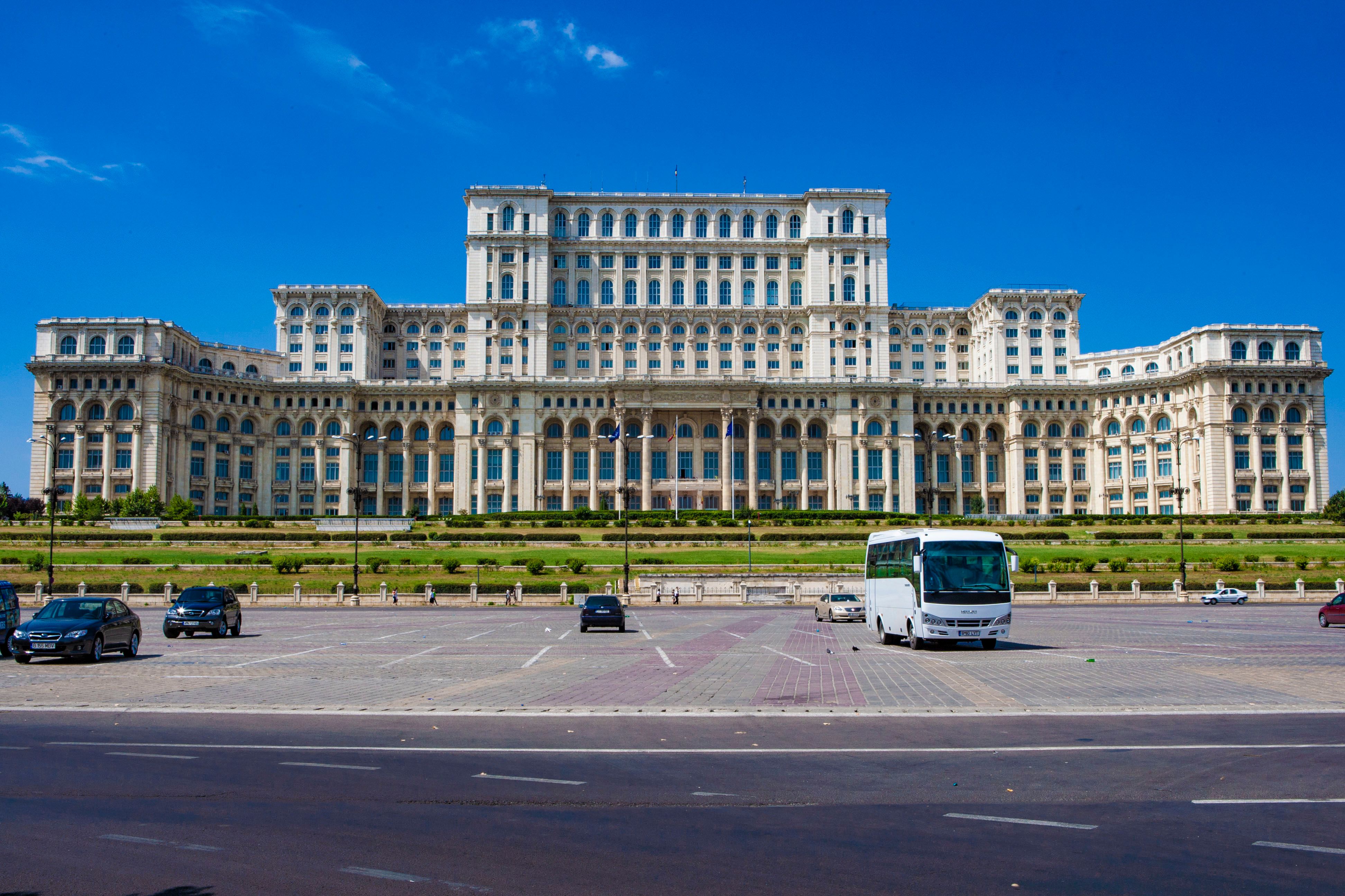 The majestic Palace of the Parliament in Bucharest, Romania, under a clear blue sky.