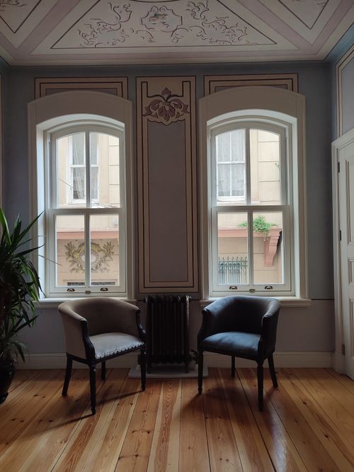 Free Cozy room with two classic chairs, wooden floor, and stylish windows. Elegant and inviting setting. Stock Photo