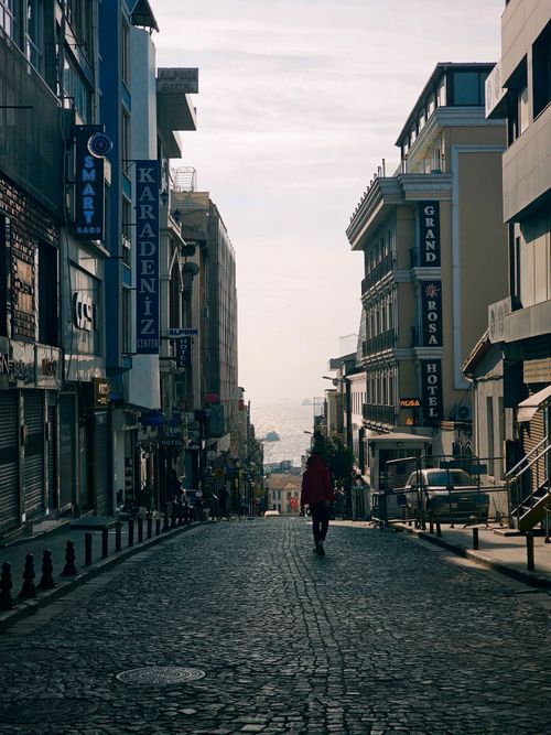 Free A scenic Istanbul street with a lone figure walking between urban architecture on a clear day. Stock Photo