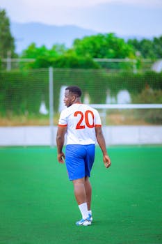 Young soccer player on the field wearing number 20 jersey, ready to play.