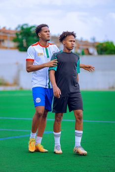 Two young soccer players on a field, ready to compete during the day.