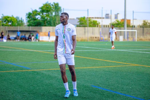 Soccer player in white kit on field, ready for action. Bright day outdoor sports scene.