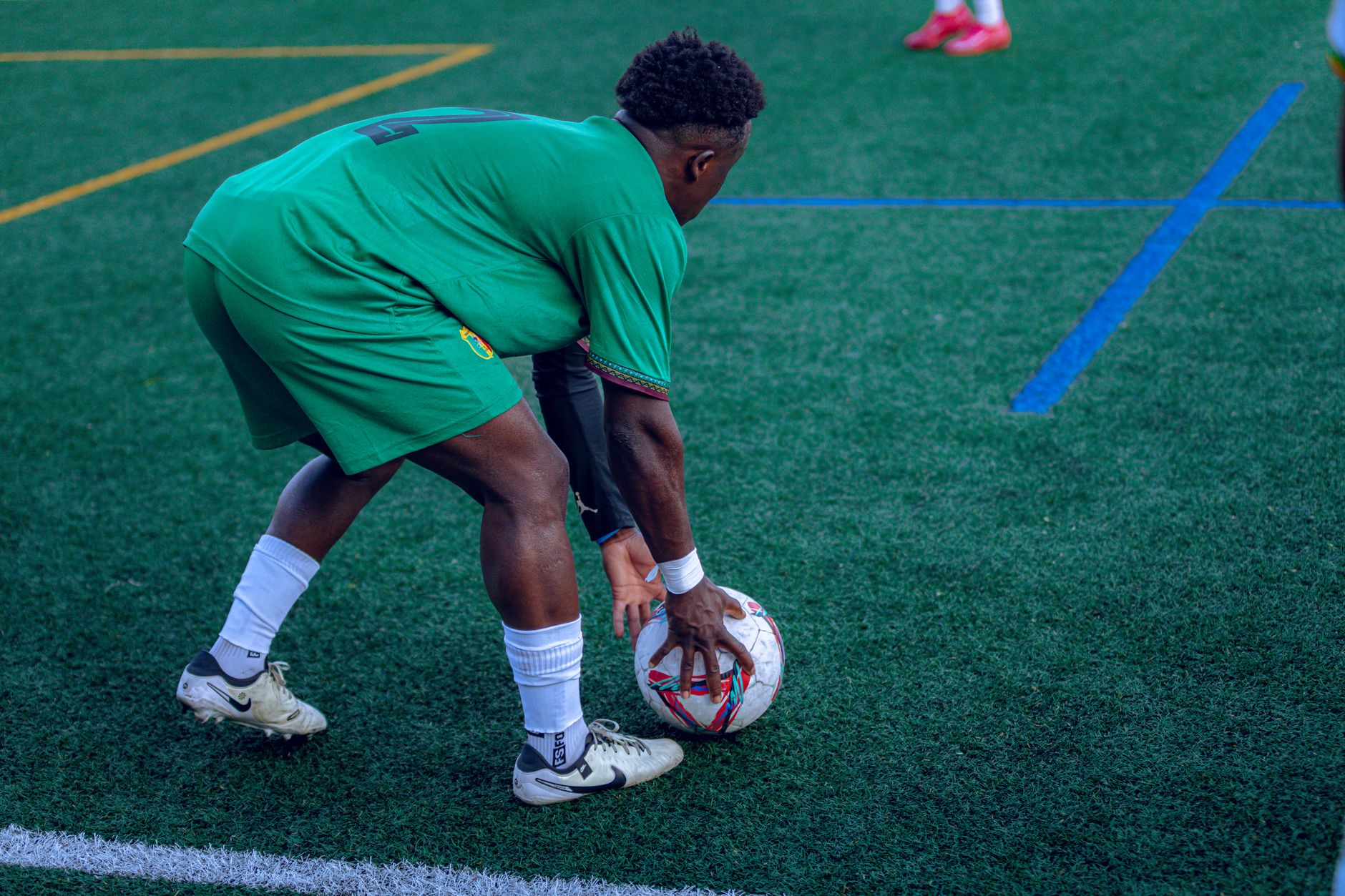Bukayo Saka preparing a corner while Liverpool defenders organise inside a crowded penalty area