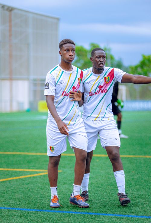 Free Two teenage soccer players in action on a green pitch during a daytime match. Stock Photo