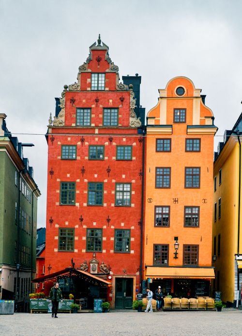 Free Vibrant red and orange historic buildings in Gamla Stan, Stockholm, Sweden showcasing traditional architecture. Stock Photo