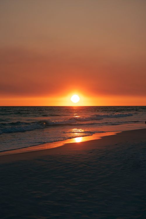 Free Breathtaking sunset over a tranquil beach in Destin, Florida, capturing the sun's reflection on the waves. Stock Photo