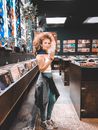 在一家时尚唱片店里，一位时尚女人拿着黑胶唱片，充满创意