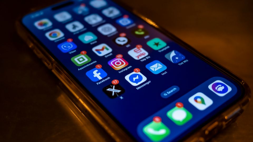 Smartphone exibindo notificações de redes sociais em uma tela escura.