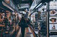 城市室内市场热闹非凡，商店林立，商品琳琅满目，人们穿梭其间购物
