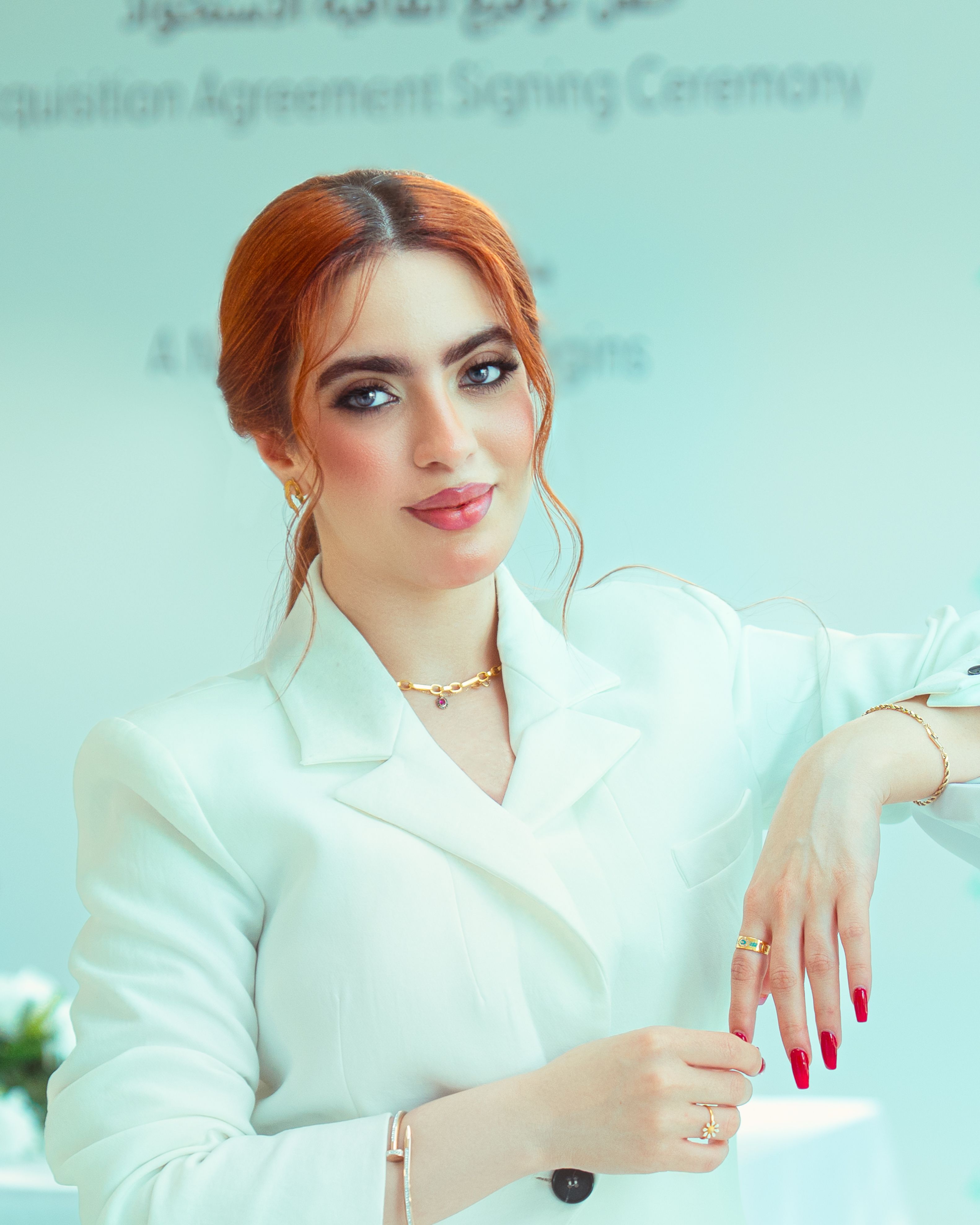 Confident woman wearing a white suit at a signing ceremony in Baghdad, Iraq.