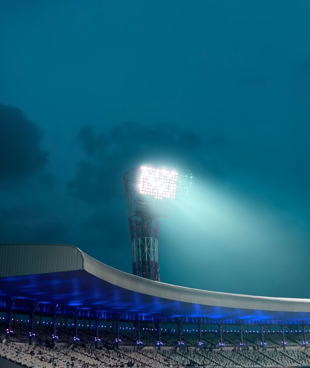 Eden Gardens cricket stadium at twilight with floodlights on, Kolkata