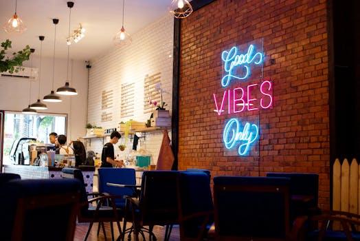 Stylish cafe in West Java boasting a 'Good Vibes Only' neon sign with modern interior design.