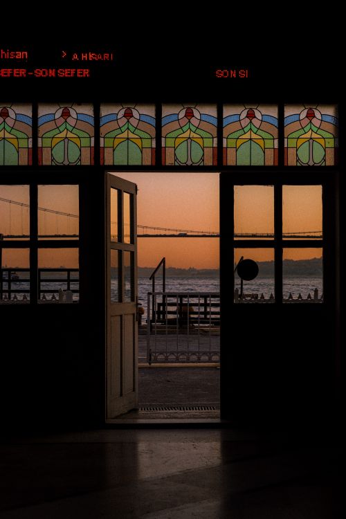 Free Beautiful sunset viewed through an ornate stained glass doorway. Stock Photo