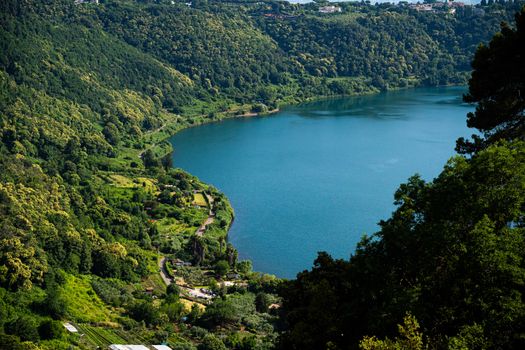 Scenic aerial view of Lake Nemi surrounded by lush greenery in Lazio, Italy.