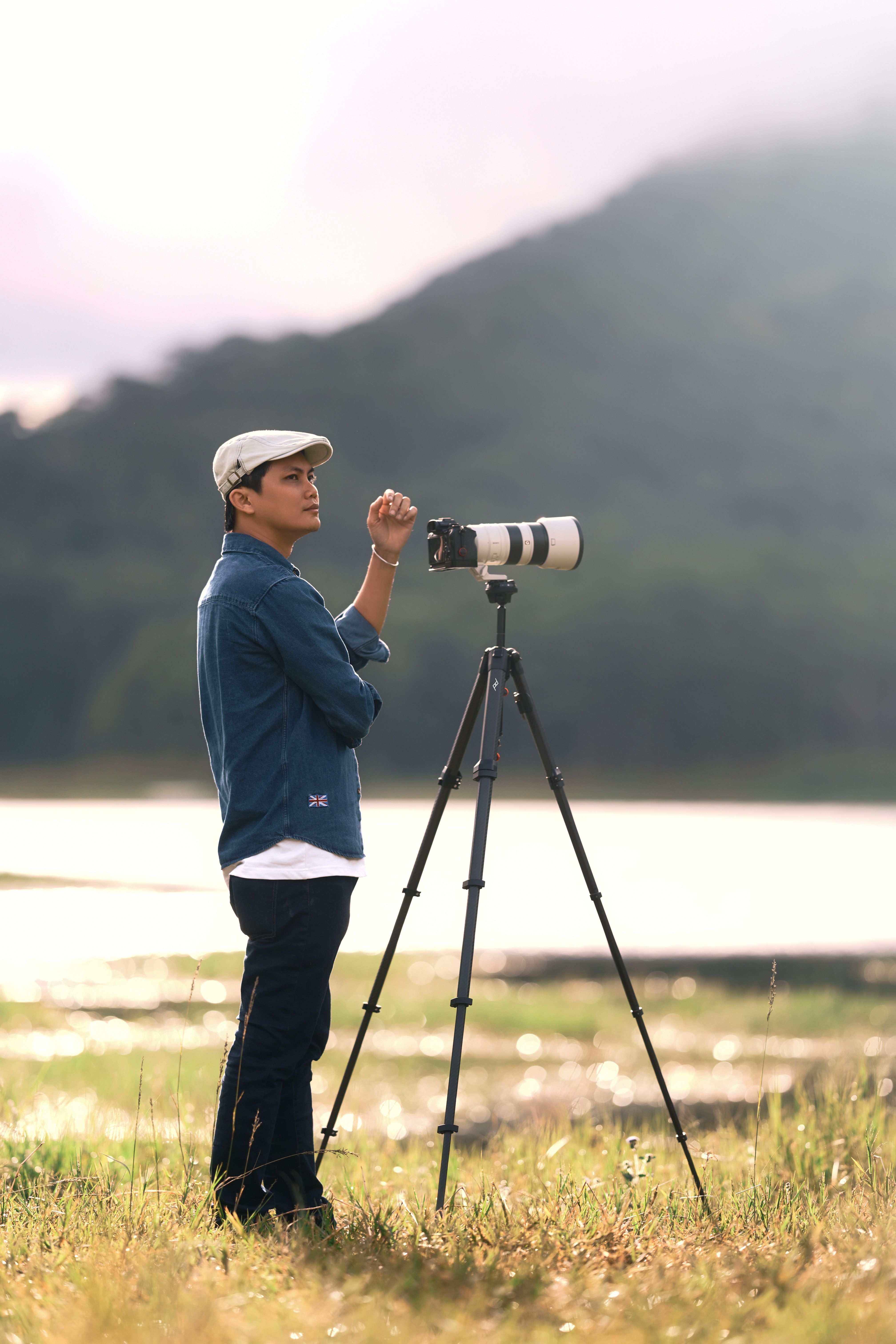 Photographer with Camera on Tripod in Scenic Outdoors · Free Stock Photo