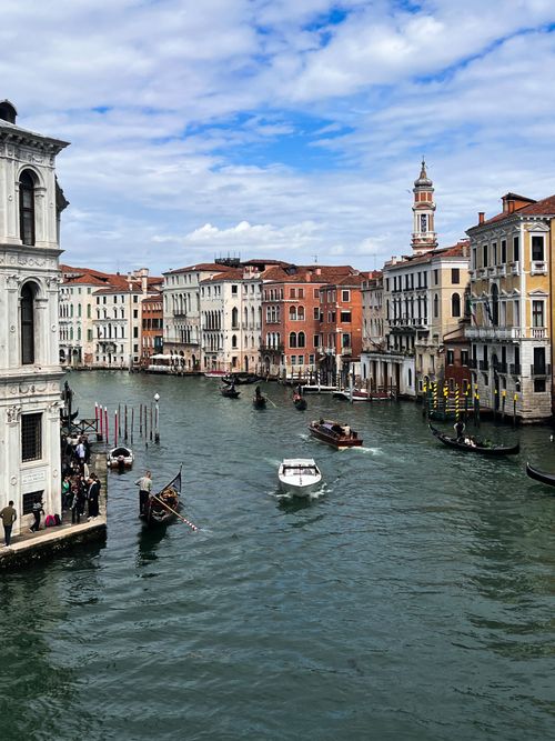Free Boats and gondolas navigate the iconic Grand Canal in Venice under a partly cloudy sky. Stock Photo