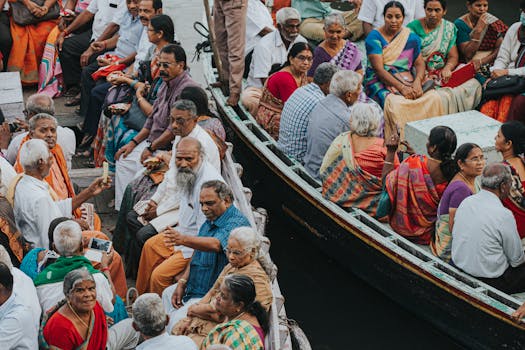 A vibrant scene of people in colorful attire gathered on boats in Varanasi, India.