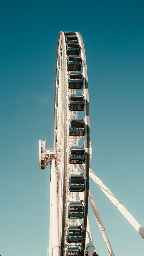 Free A stunning view of a Ferris wheel in Chicago against a clear blue sky, capturing modern architecture. Stock Photo