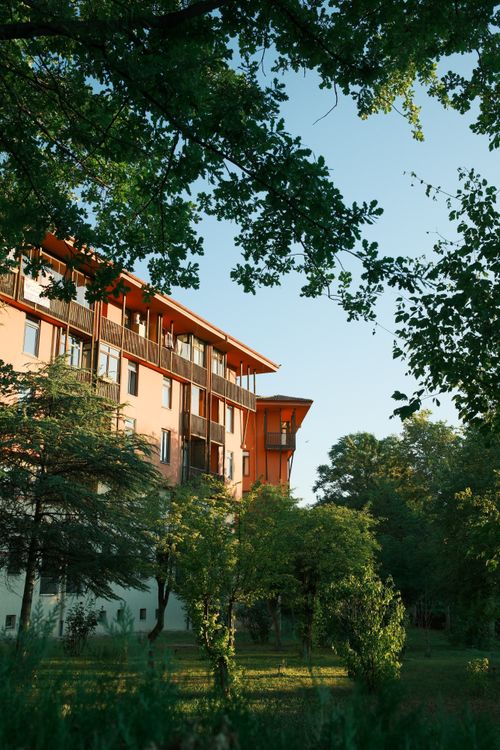 Free Modern apartment building surrounded by lush greenery on a sunny day, perfect for nature lovers. Stock Photo