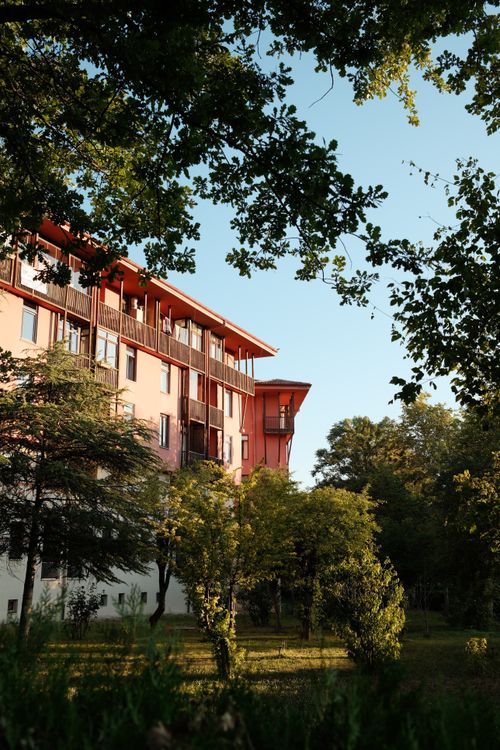 Free A contemporary apartment complex nestled in lush greenery under a clear blue sky. Stock Photo