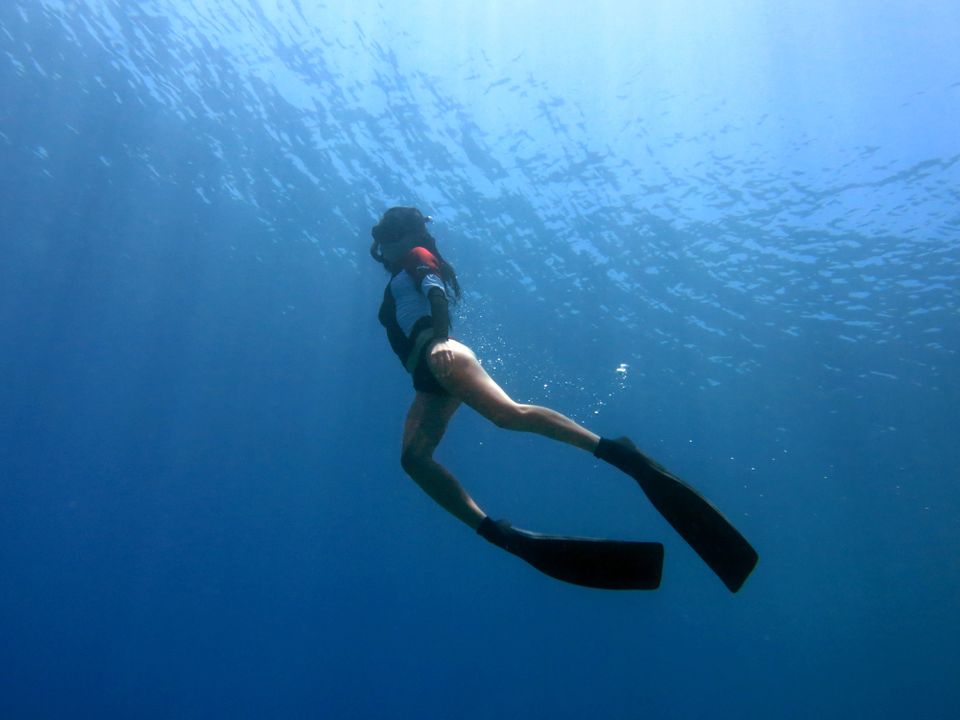 Un free diver esplora il profondo mare blu a Bodrum, Turchia, mostrando la tranquillità dell'avventura subacquea.
