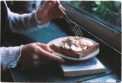 Rustic breakfast of banana and almond toast near a window with natural light.
