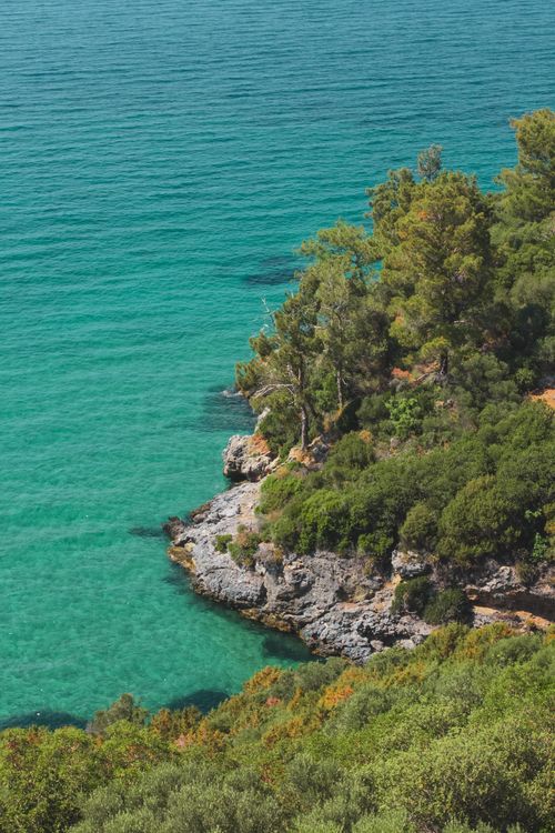Free Aerial view of a turquoise sea against lush green cliffs, perfect for travel or nature themes. Stock Photo