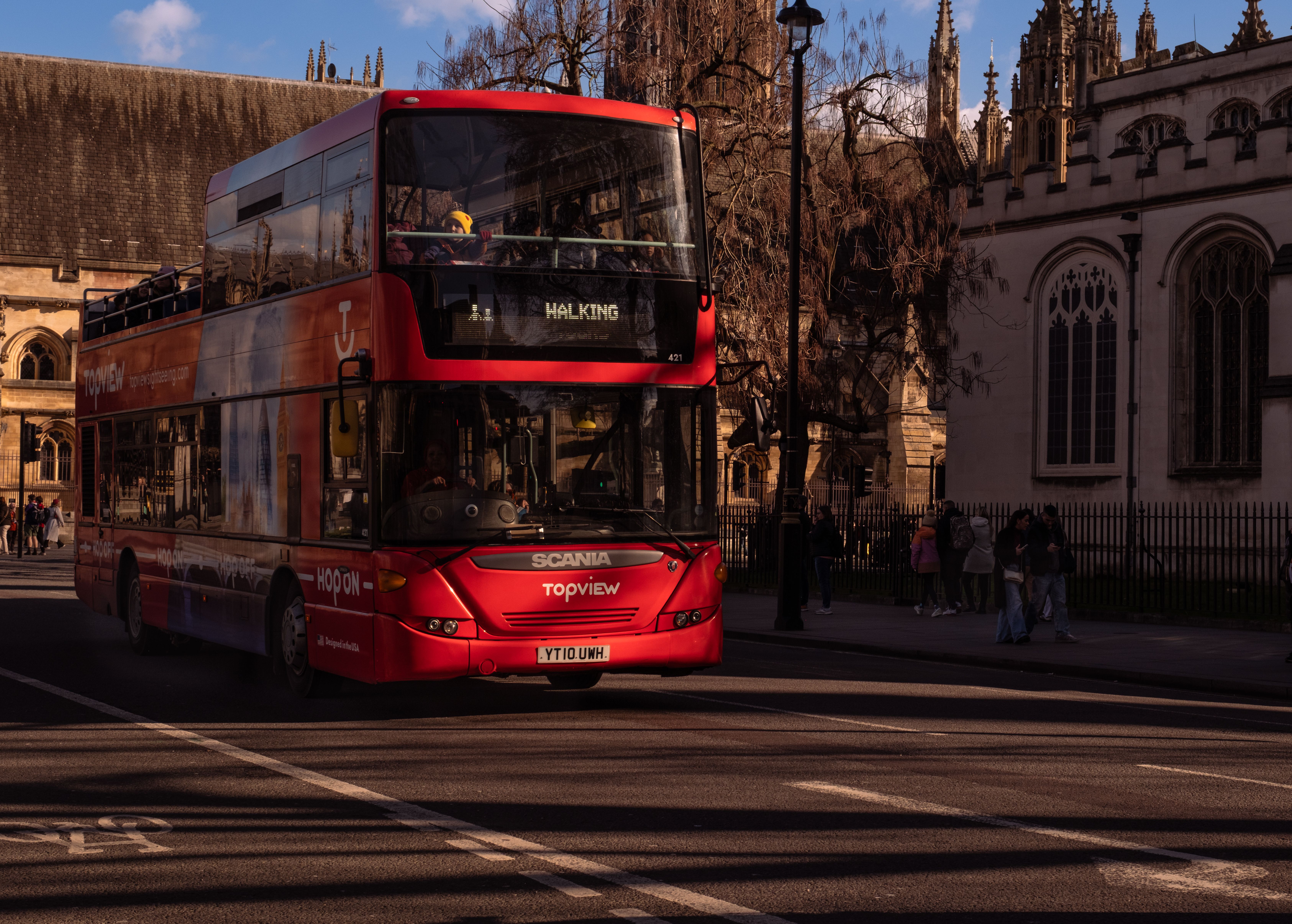 A classic red London double-decker bus captured against historic city architecture.