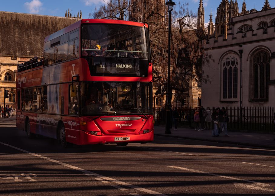 A classic red London double-decker bus captured against historic city architecture.