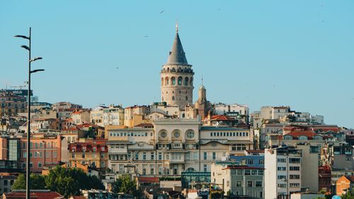 Free View of historical Galata Tower with vibrant Istanbul cityscape under blue sky. Stock Photo
