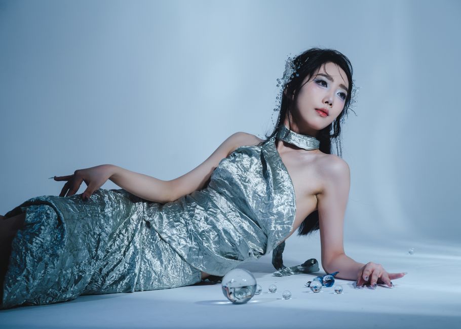 Artistic portrait of a woman in a silver metallic dress, captured in a modern style with a cool tone.