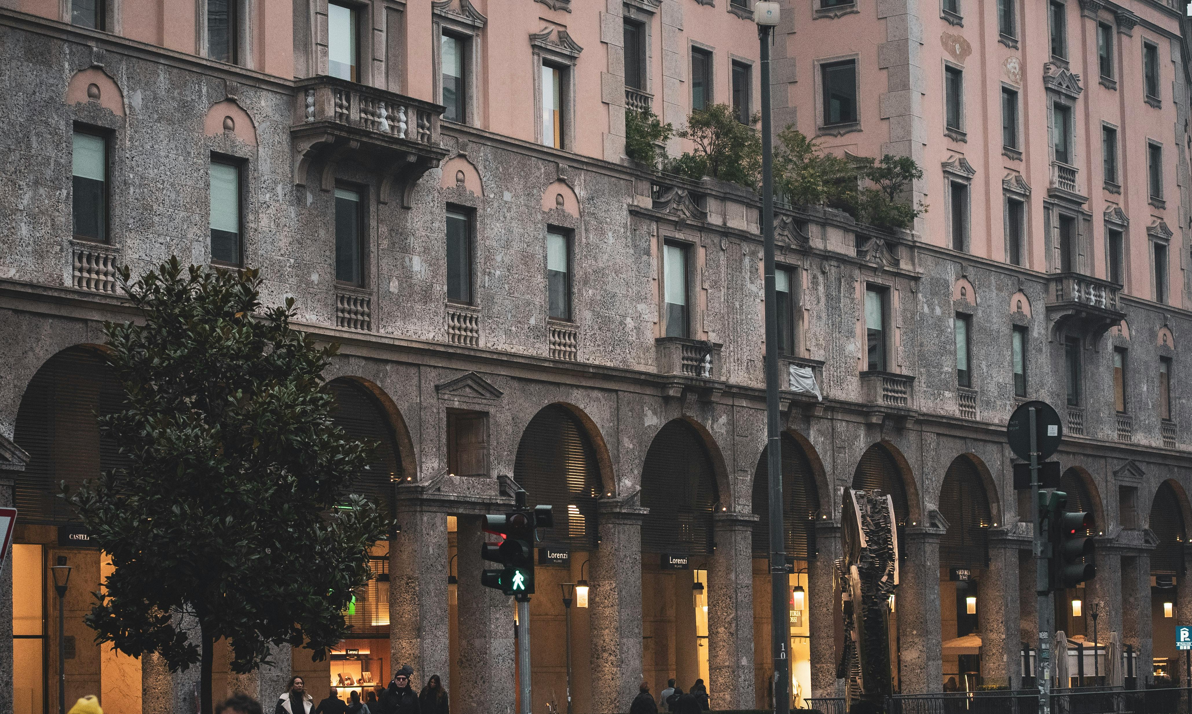 Historic building facade in Milan with arched walkways and evening ambiance. - Milán