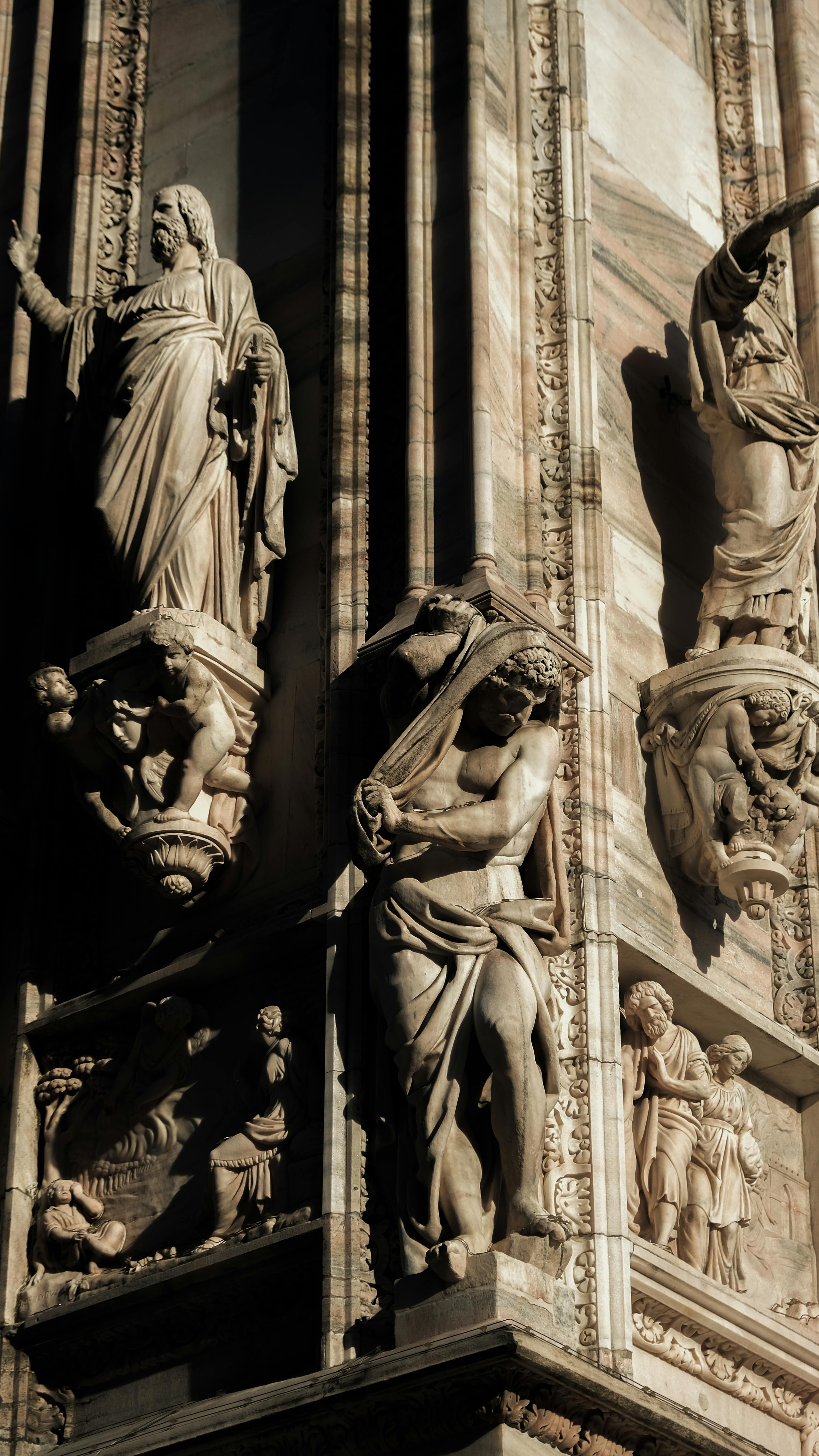Intricate sculptures adorn the facade of a Gothic cathedral, showcasing detailed craftsmanship and historical artistry.