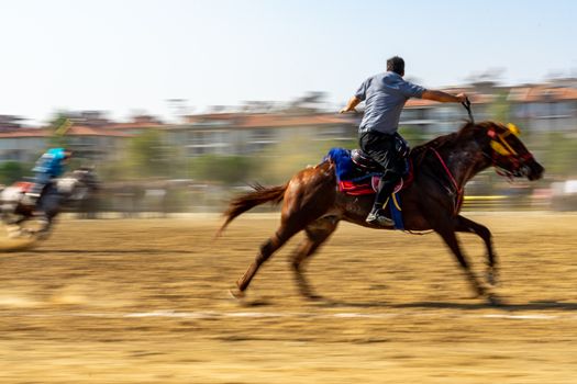 Energetic scene of a horse race in Salihli, capturing speed and motion blur in a sunny setting. — photo by Deniz ŞENGÜL