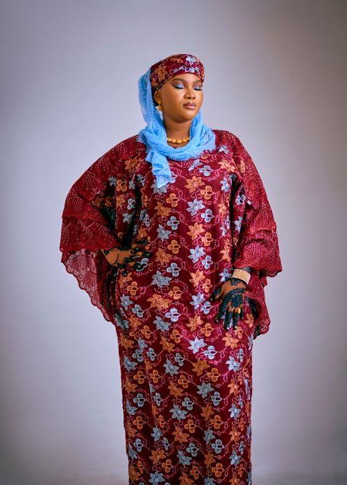 Free Woman wearing detailed red and blue African traditional attire with intricate patterns. Stock Photo