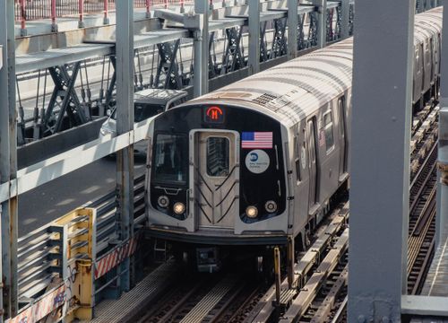 Free A New York City subway train travels on elevated tracks on a sunny day. Stock Photo