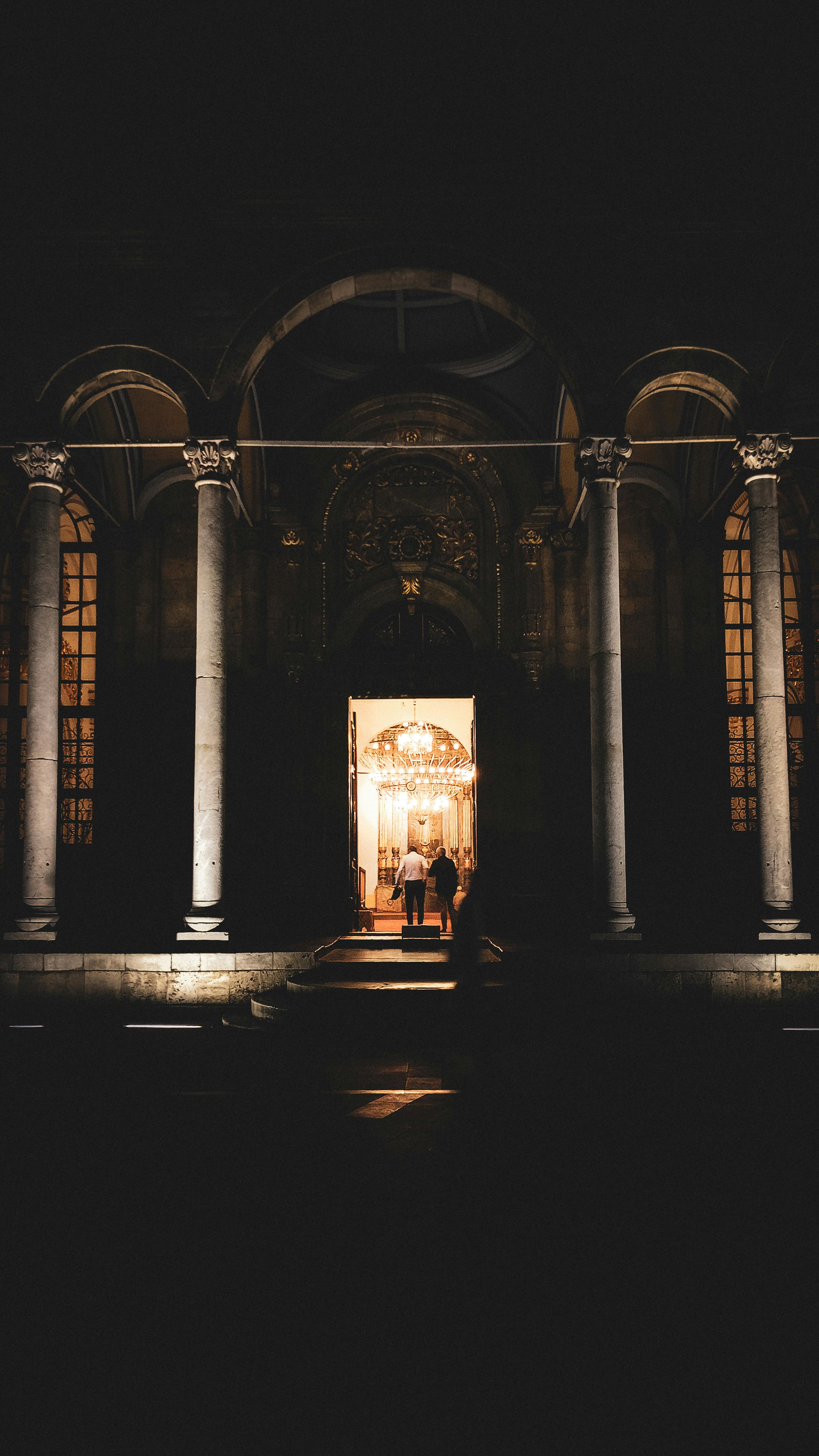 Elegant illuminated entrance with grand columns in Konya, Türkiye at night.