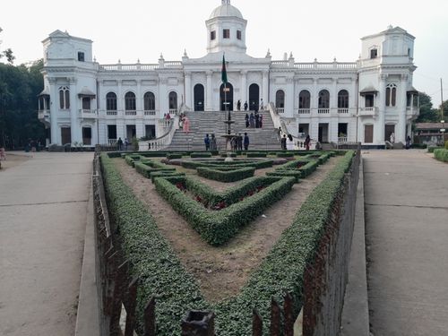Free Elegant white palace facade with manicured gardens in foreground, showcasing historical architecture. Stock Photo