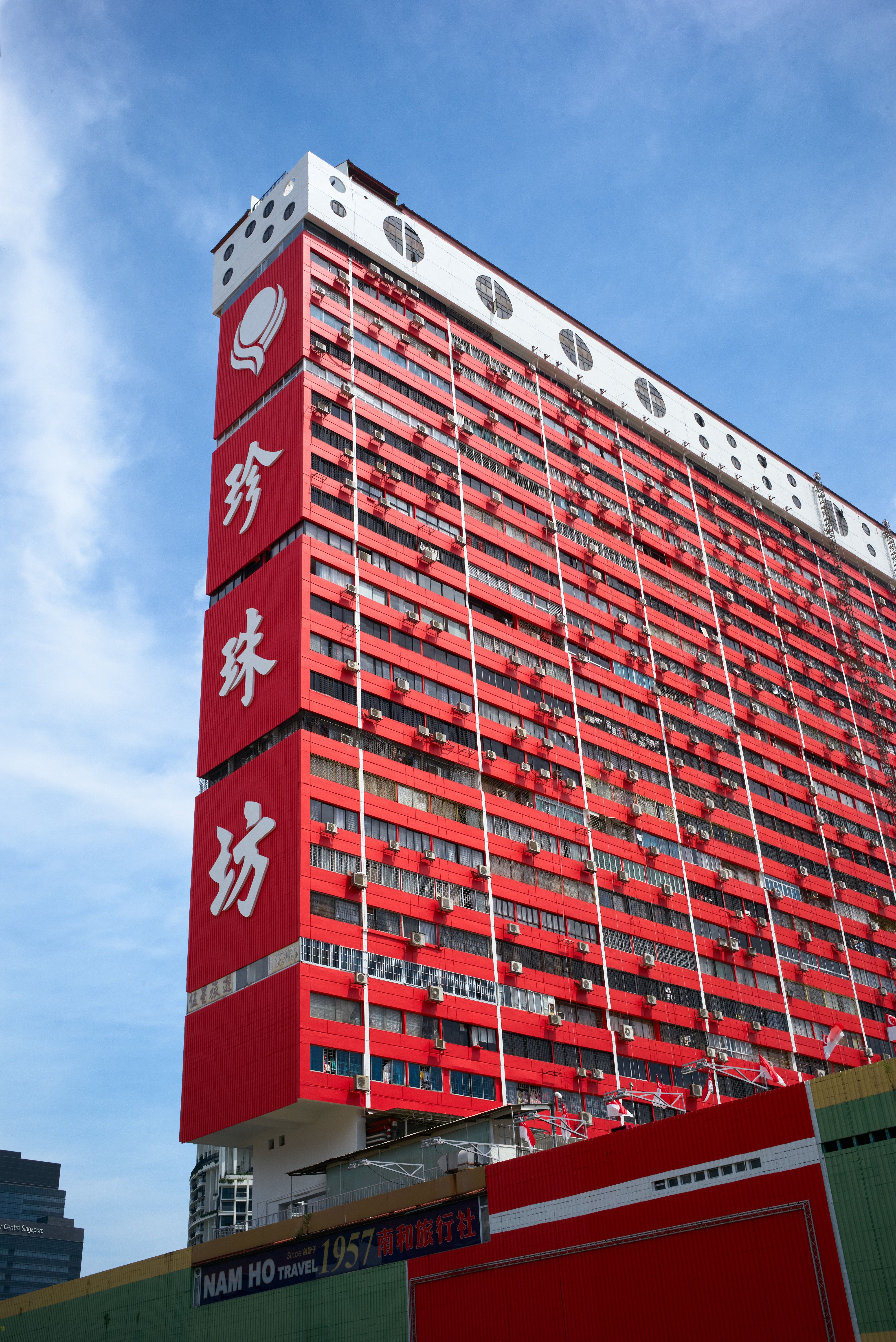 Striking red building with Chinese characters under clear blue sky.