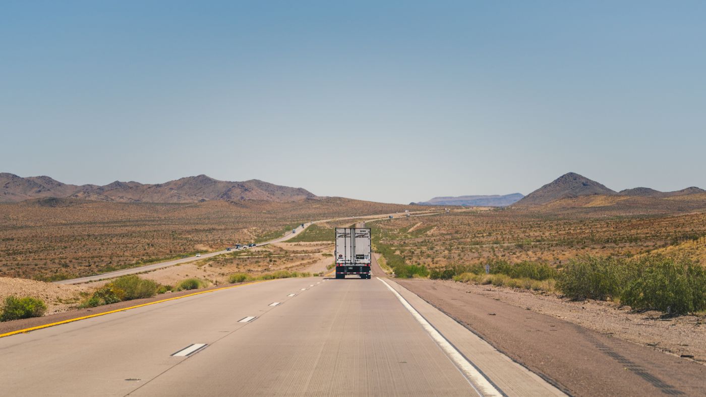 OTR truck driving along a highway through open desert