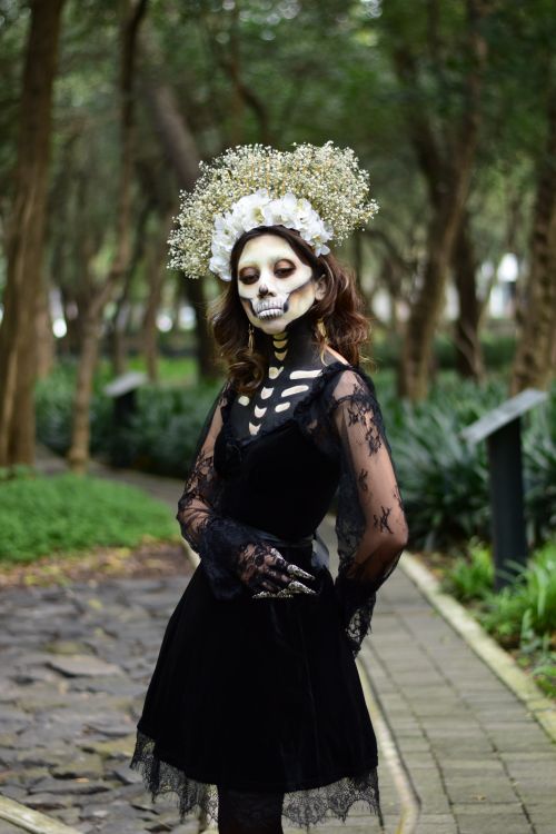 Free Dramatic gothic portrait of a woman with skeleton makeup in a lush forest. Stock Photo