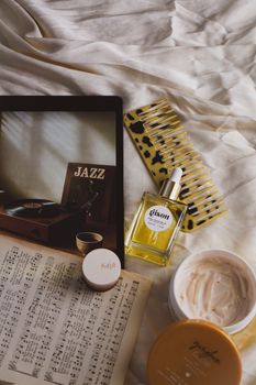 Trendy flat lay featuring beauty products and jazz-themed decor on fabric.