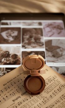 Elegant combination of makeup and sheet music on a tablet, creating a vintage ambiance.