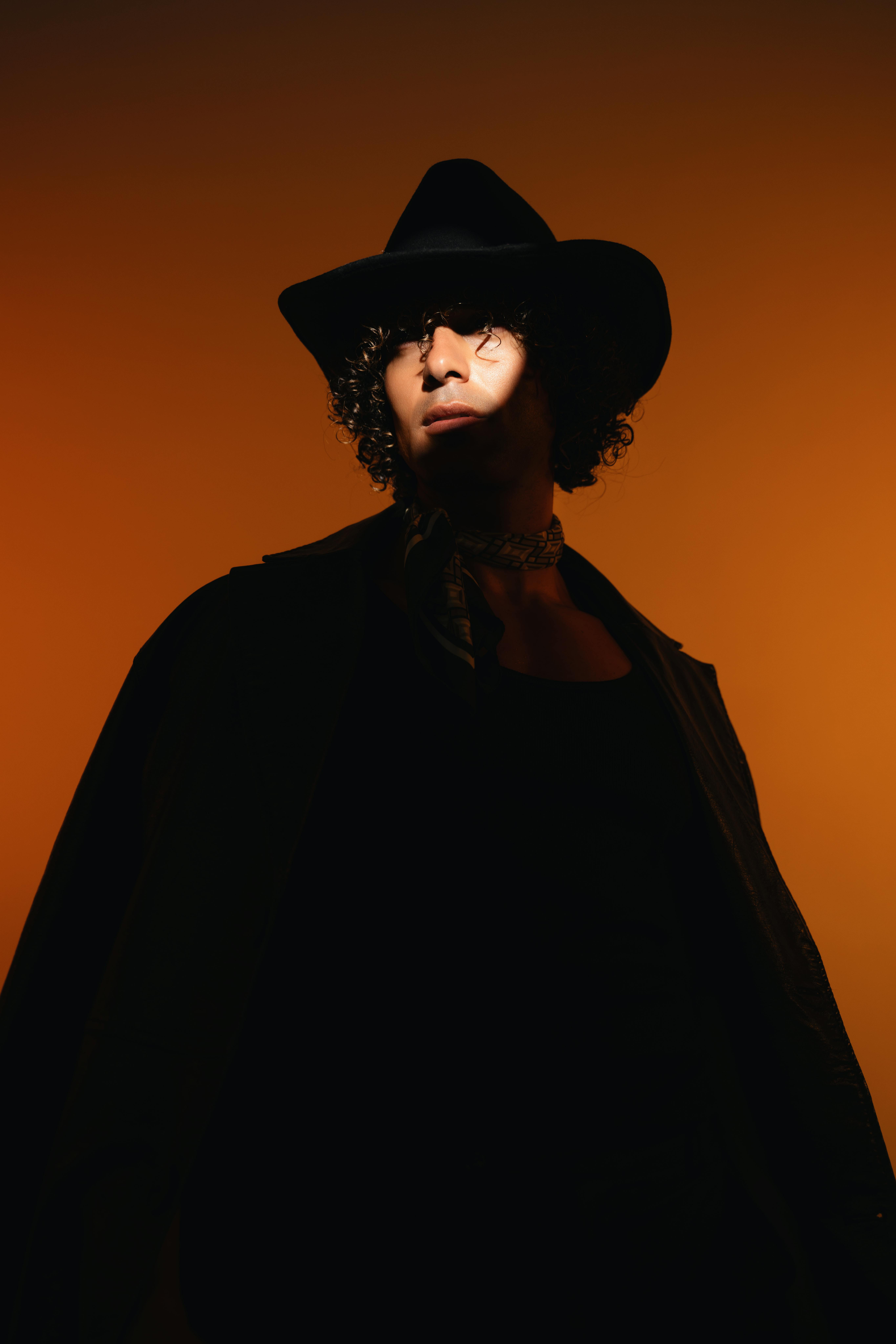 Artistic portrait of a stylish man highlighting modern masculinity with dramatic lighting and fashion-forward style.