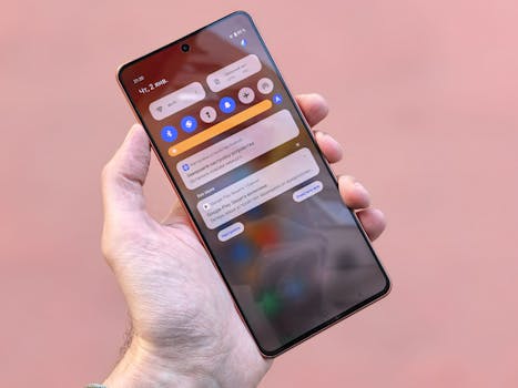 Close-up view of a person holding a smartphone showing notifications and icons on screen.