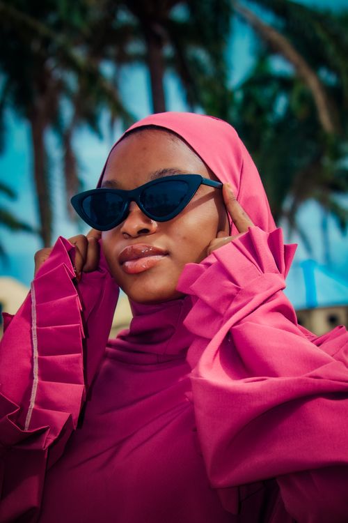Free Stylish young woman wearing sunglasses and a pink outfit outdoors, exuding confidence. Stock Photo
